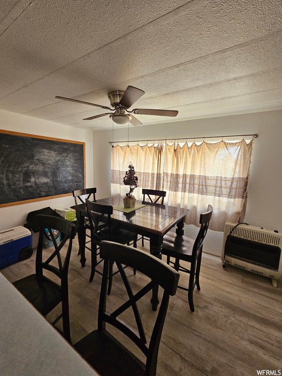 Dining area featuring ceiling fan, a textured ceiling, and hardwood floors