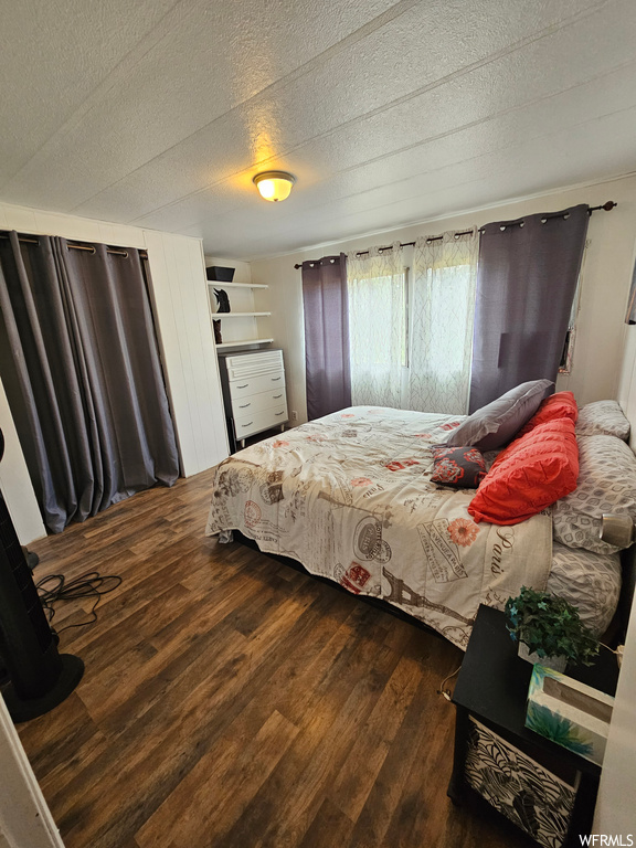 Hardwood floored bedroom with a textured ceiling
