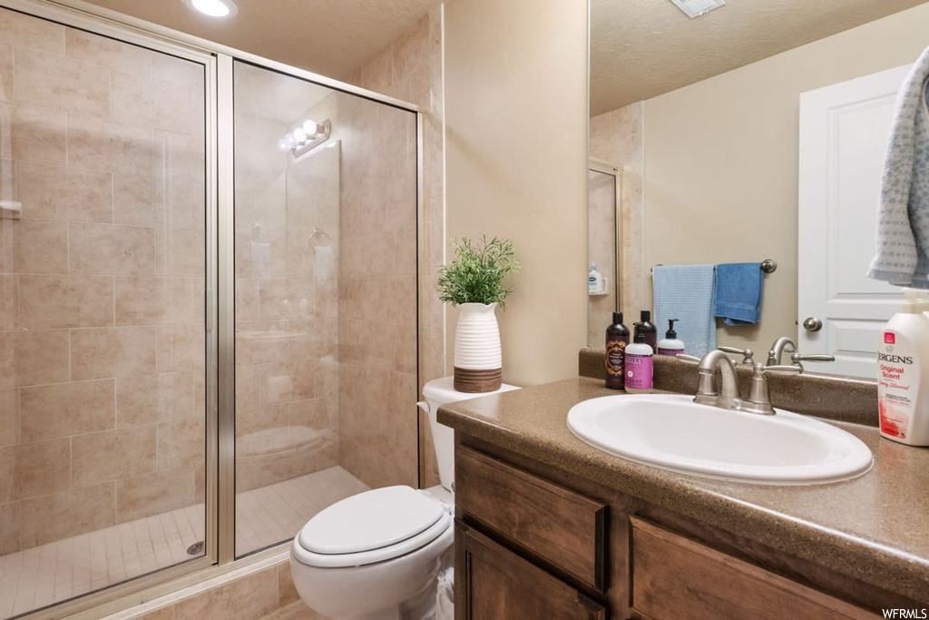 Full bathroom with toilet, mirror, oversized vanity, and shower with shower door