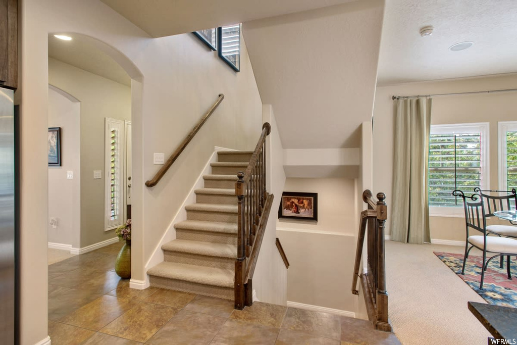 Stairs with natural light and tile floors