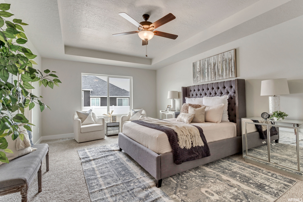 Carpeted bedroom with natural light and a ceiling fan