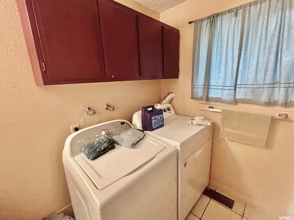 Laundry room featuring tile floors and independent washer and dryer