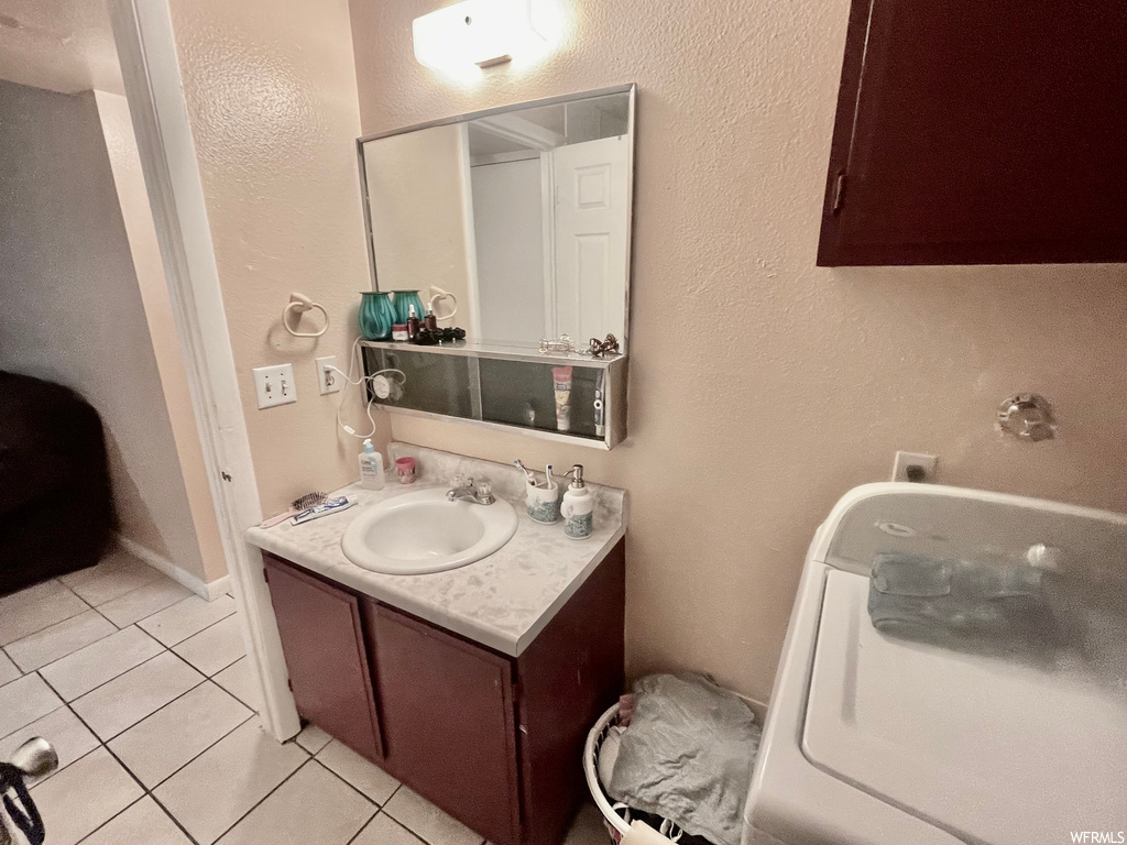 Bathroom with tile floors, oversized vanity, and mirror