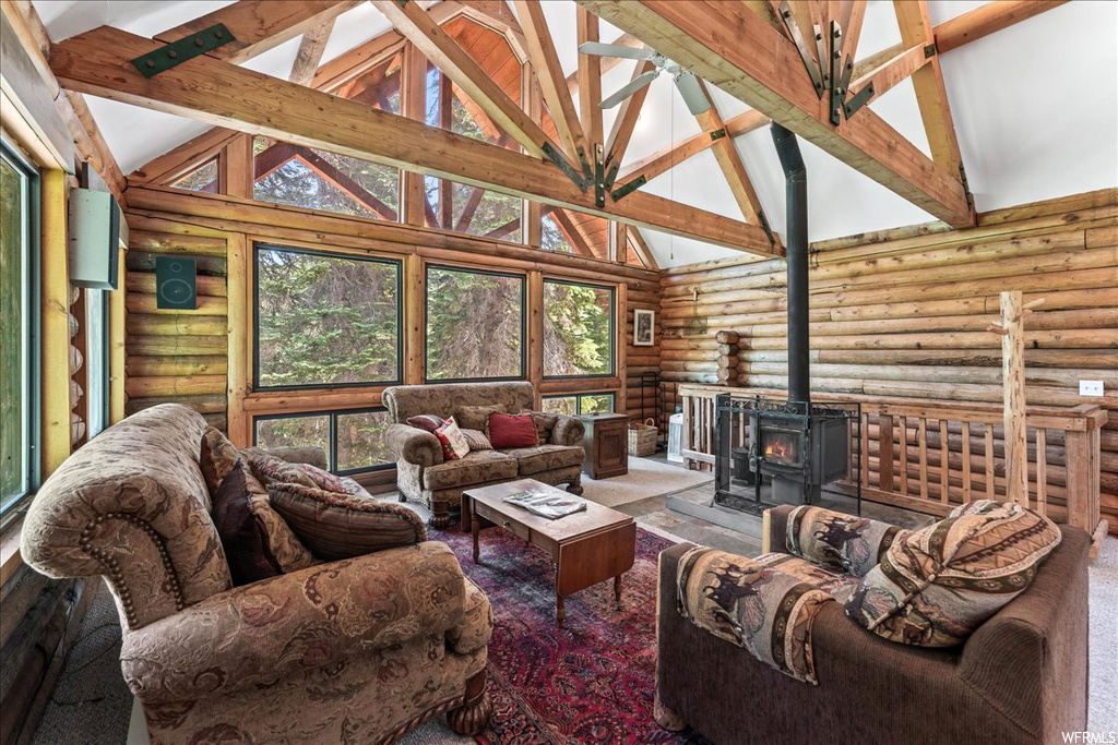 Living room with a fireplace, natural light, and lofted ceiling with beams