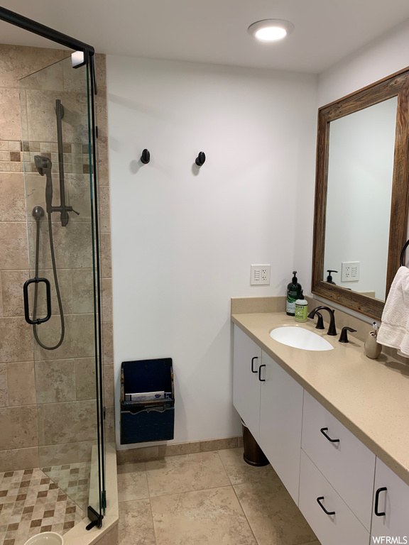 Bathroom with enclosed shower, mirror, and vanity