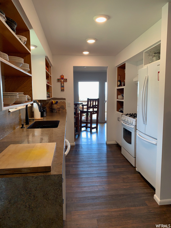 Kitchen with natural light, gas range oven, refrigerator, and dark parquet floors