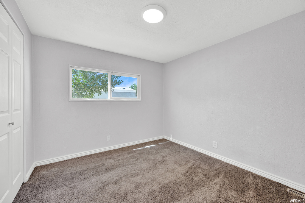 Empty room with natural light and carpet