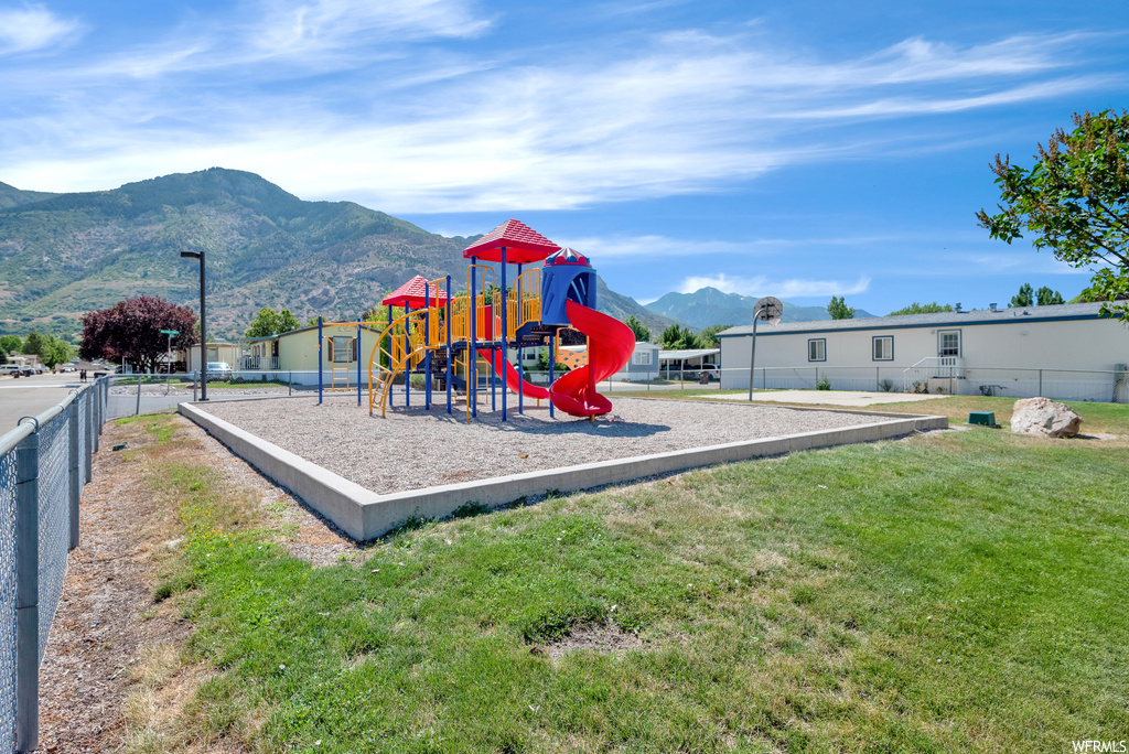 View of playground with a yard and a mountain view