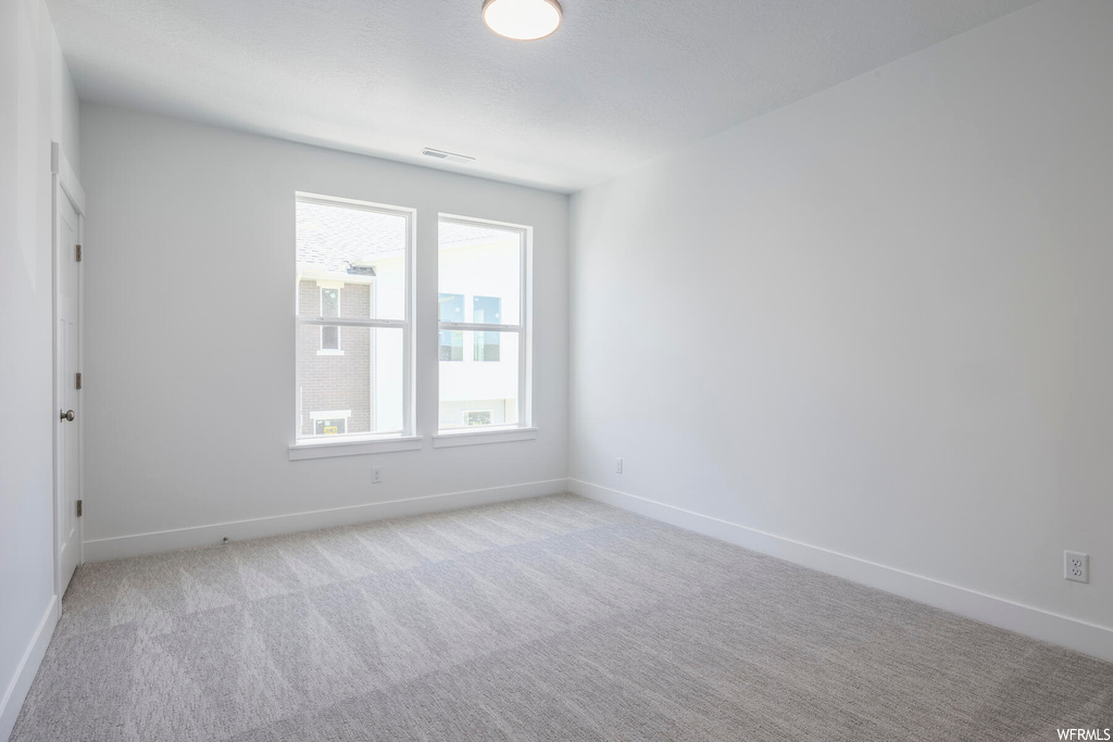 Empty room featuring light carpet