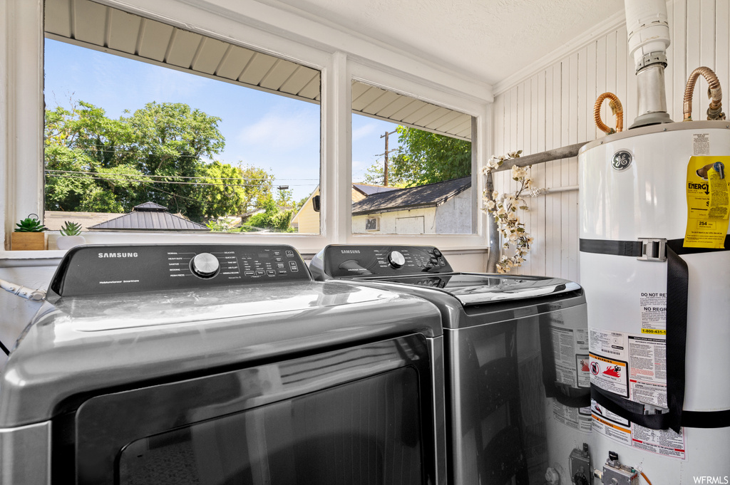 Laundry room with crown molding, separate washer and dryer, and gas water heater