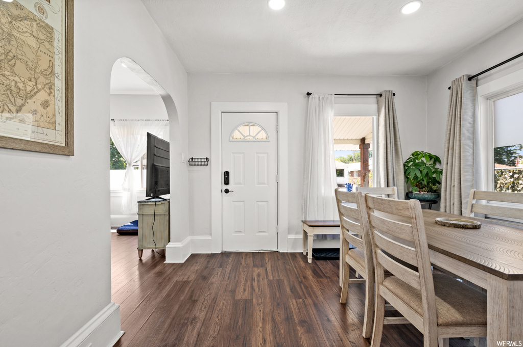Wood floored entryway featuring a healthy amount of sunlight and TV
