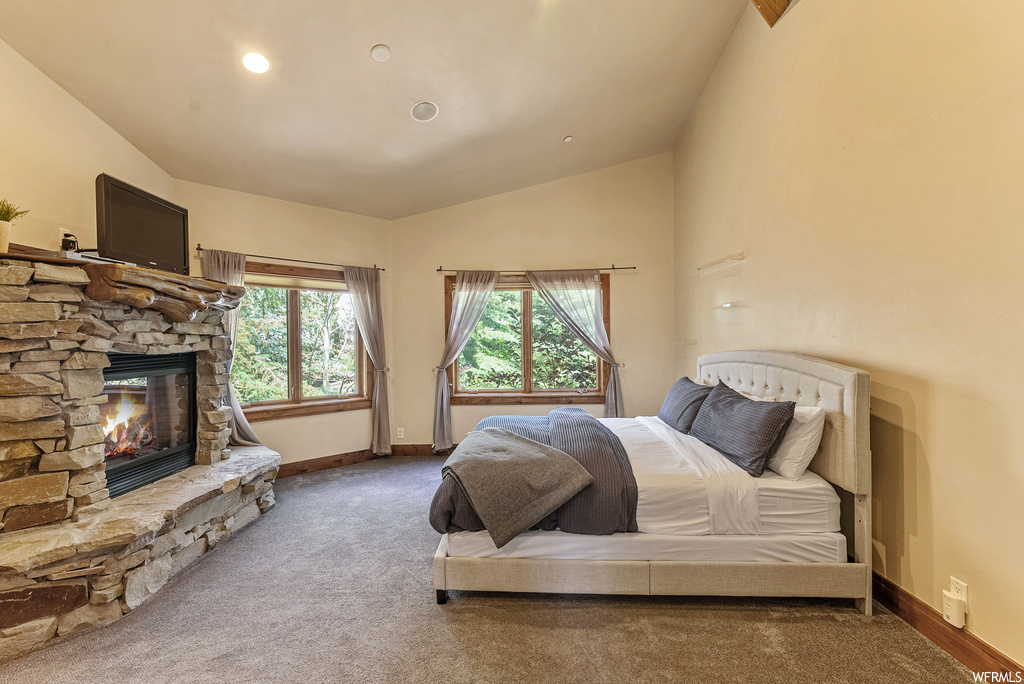Bedroom featuring light carpet, vaulted ceiling, and TV