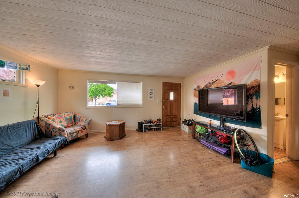 Living room featuring ornamental molding and light hardwood flooring