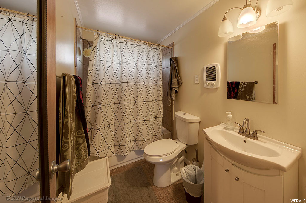 Bathroom featuring vanity, crown molding, and mirror