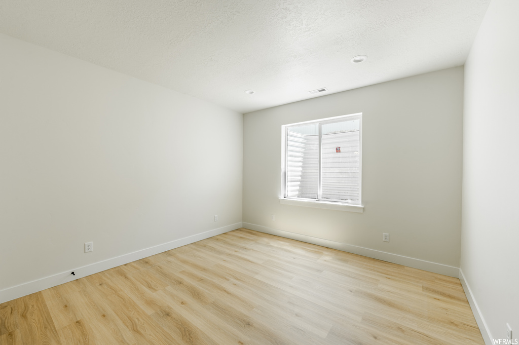 Empty room featuring light hardwood flooring