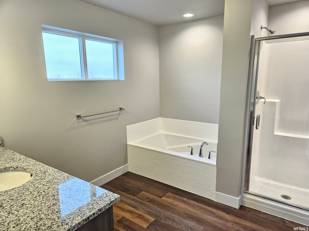 Bathroom with vanity, plus walk in shower, and hardwood / wood-style floors