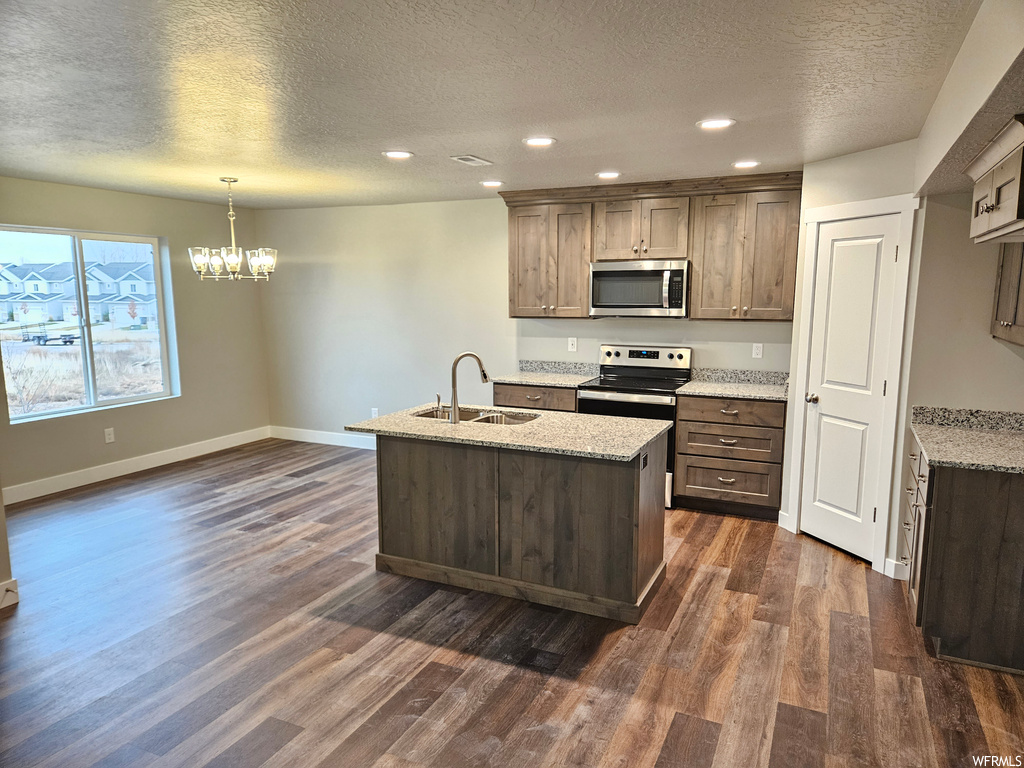 Kitchen featuring sink, a chandelier, stainless steel appliances, dark hardwood / wood-style flooring, and decorative light fixtures