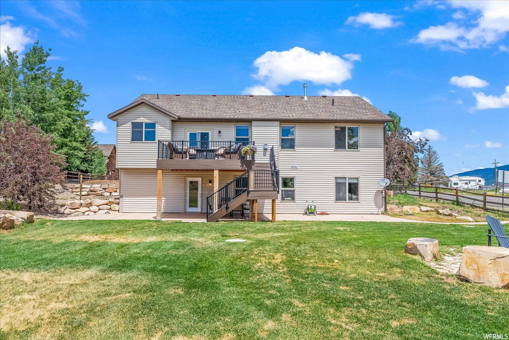 Back of house with a patio, a lawn, and wooden deck