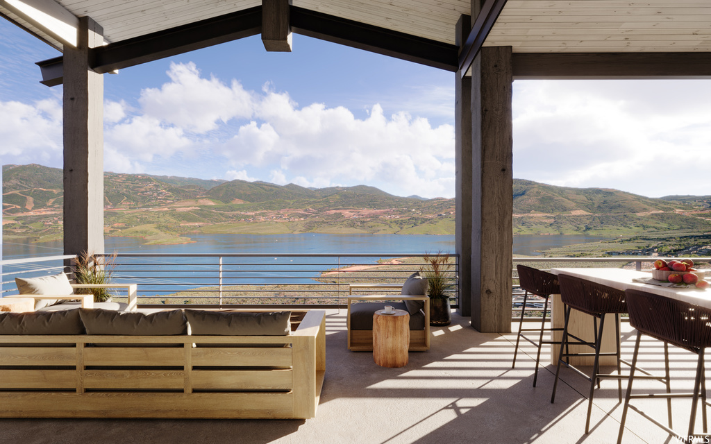 View of patio / terrace with a water and mountain view, balcony, and an outdoor living space