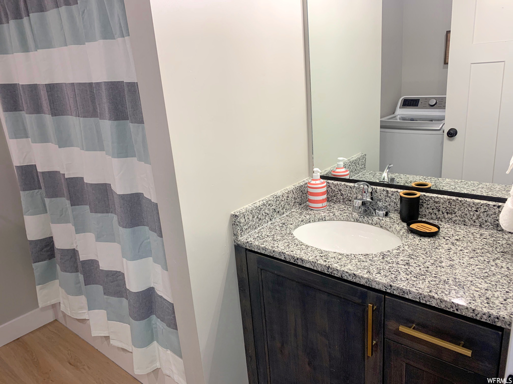 Bathroom featuring vanity, hardwood flooring, and mirror