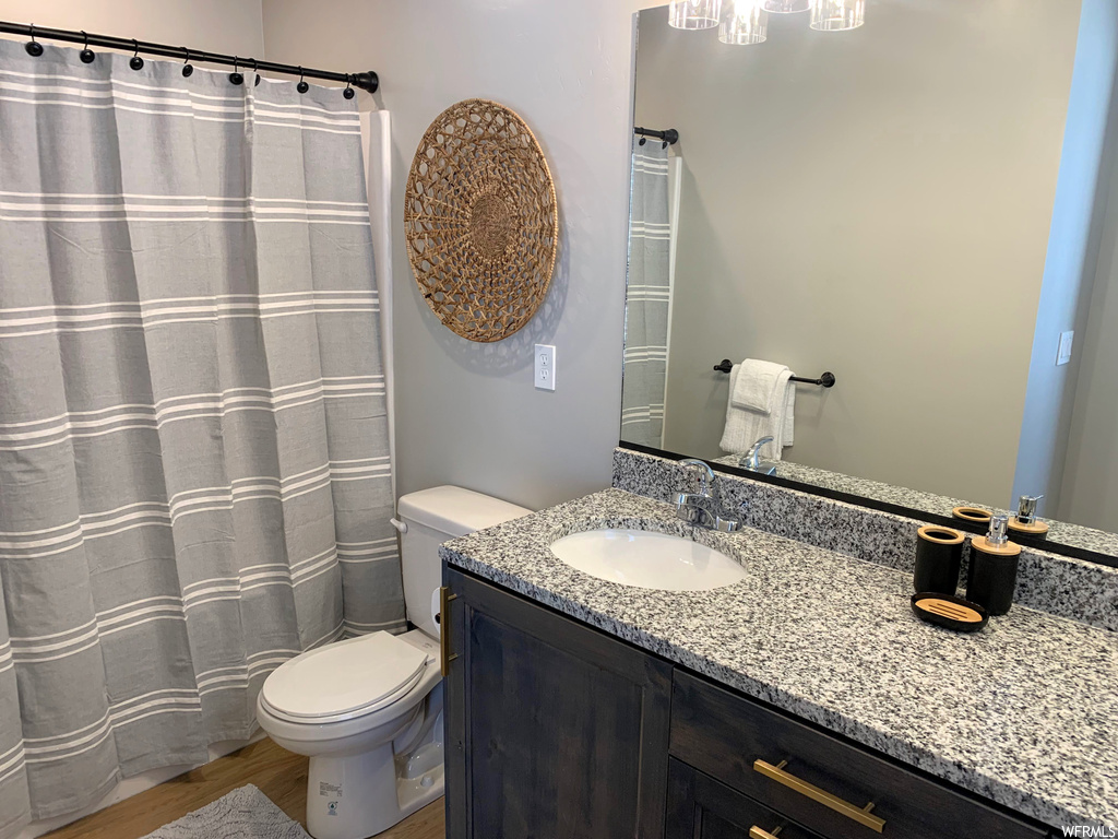 Bathroom featuring hardwood flooring, vanity, and mirror