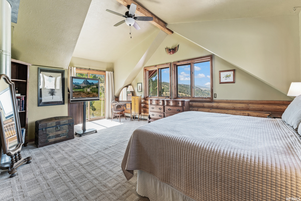 Bedroom with multiple windows, vaulted ceiling with beams, light carpet, and ceiling fan