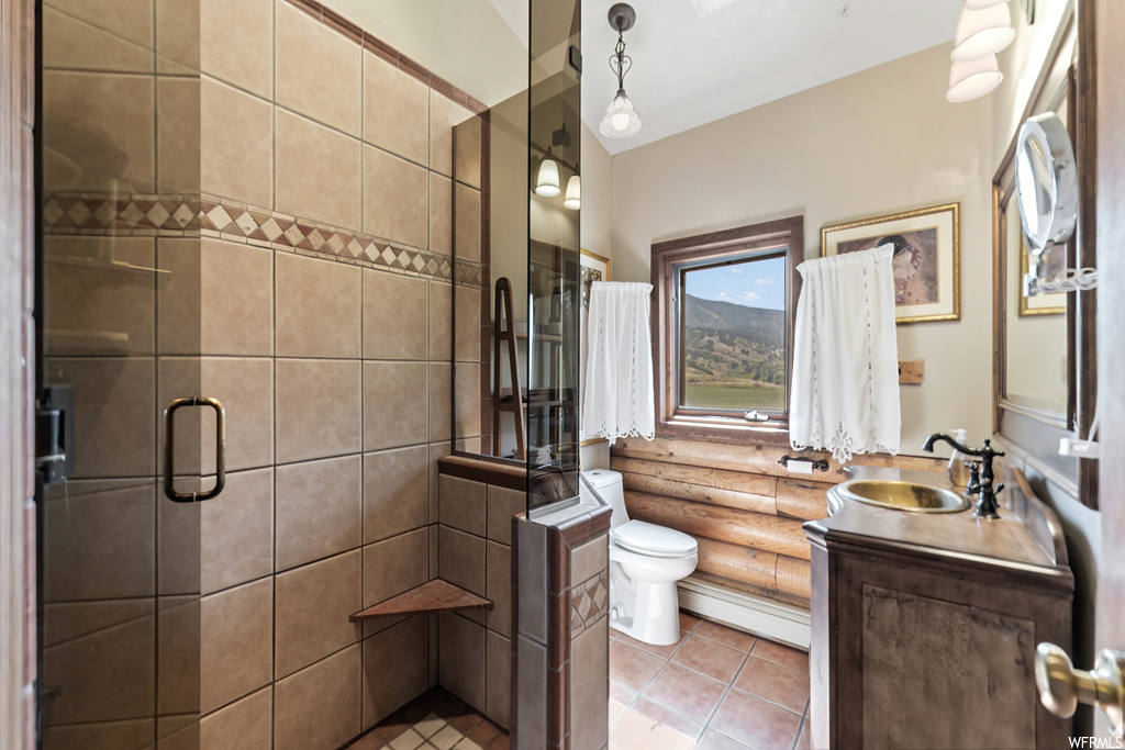 Bathroom featuring an enclosed shower, vanity, mirror, and light tile floors