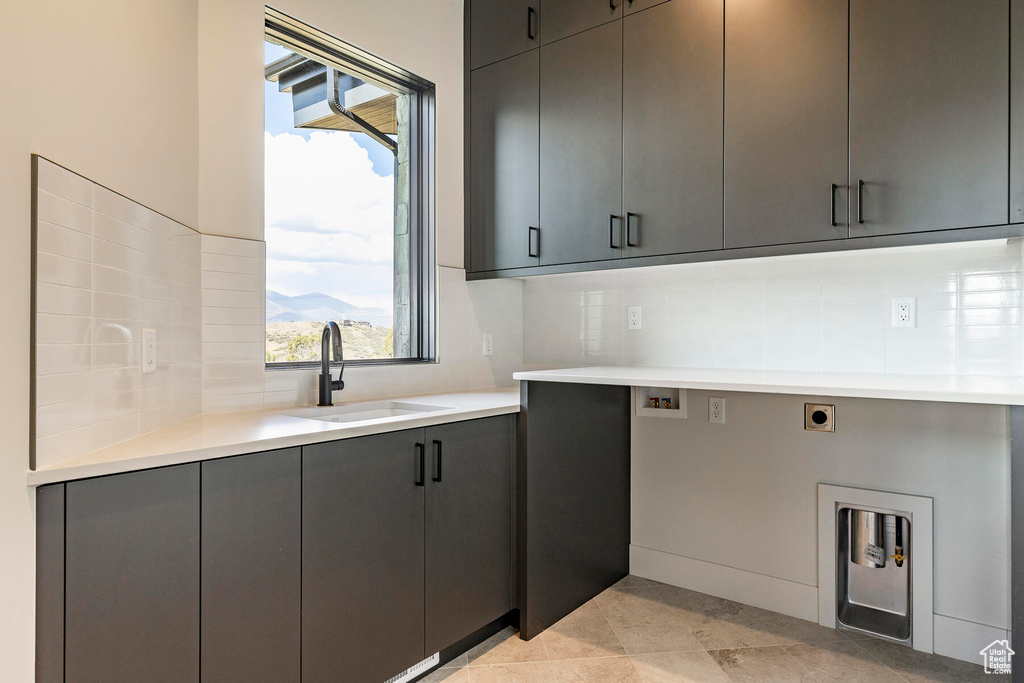 Kitchen with sink, tasteful backsplash, gray cabinetry, and light tile floors