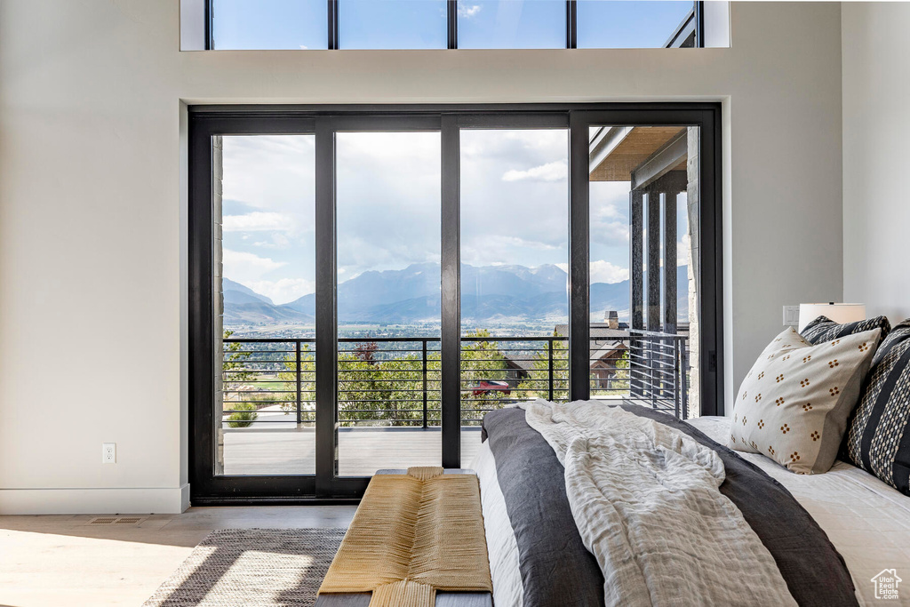 Bedroom featuring a mountain view, light wood-type flooring, and access to exterior