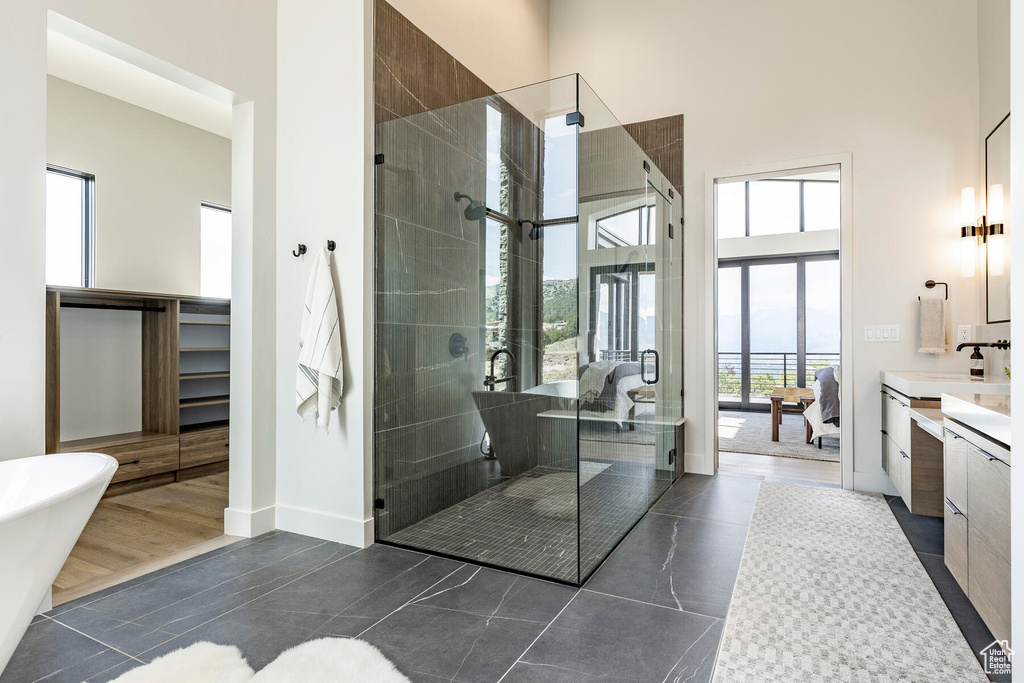 Bathroom with vanity, tile floors, a towering ceiling, and separate shower and tub