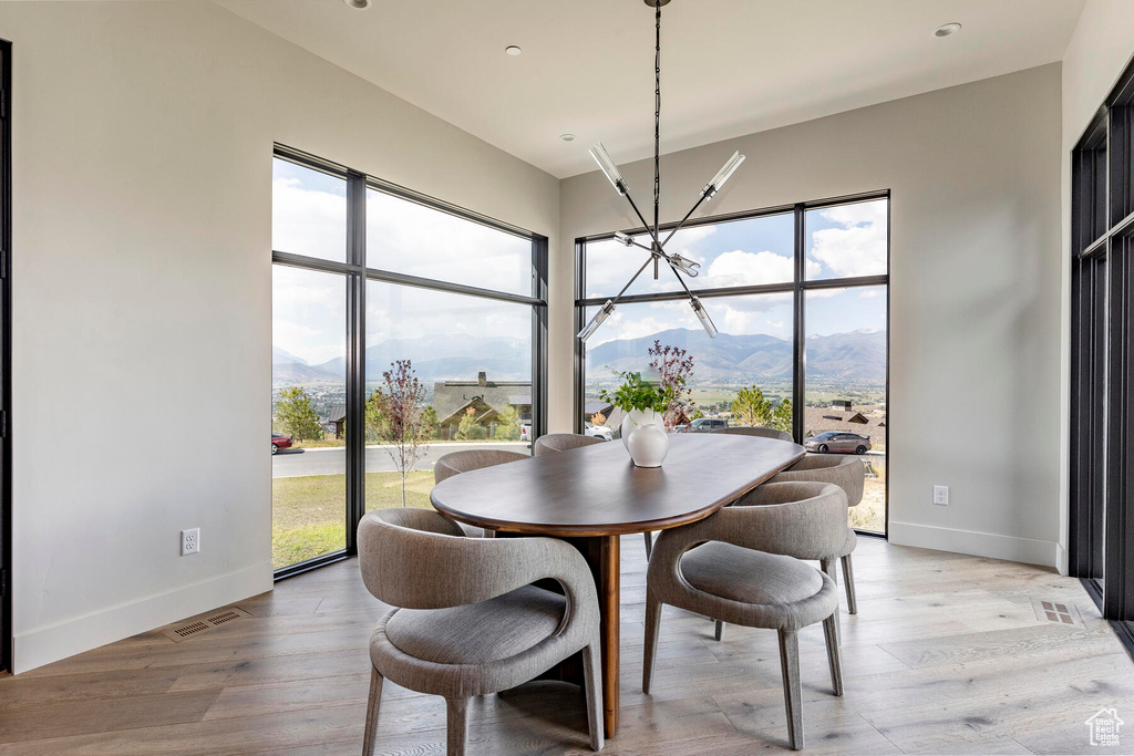 Dining room featuring a mountain view, light hardwood / wood-style flooring, and an inviting chandelier