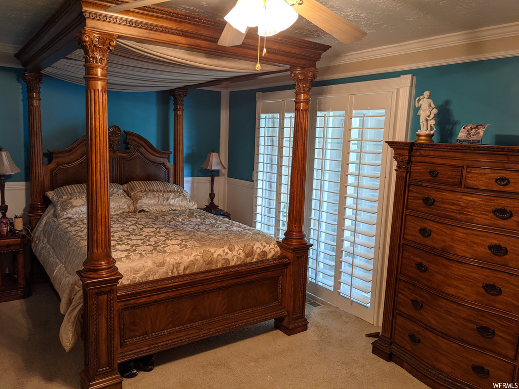 Bedroom featuring ornamental molding, multiple windows, ceiling fan, and light carpet