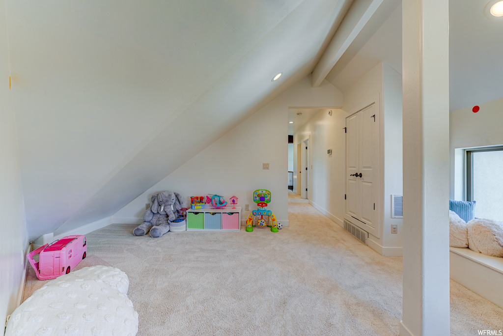 Playroom with light carpet and lofted ceiling with beams