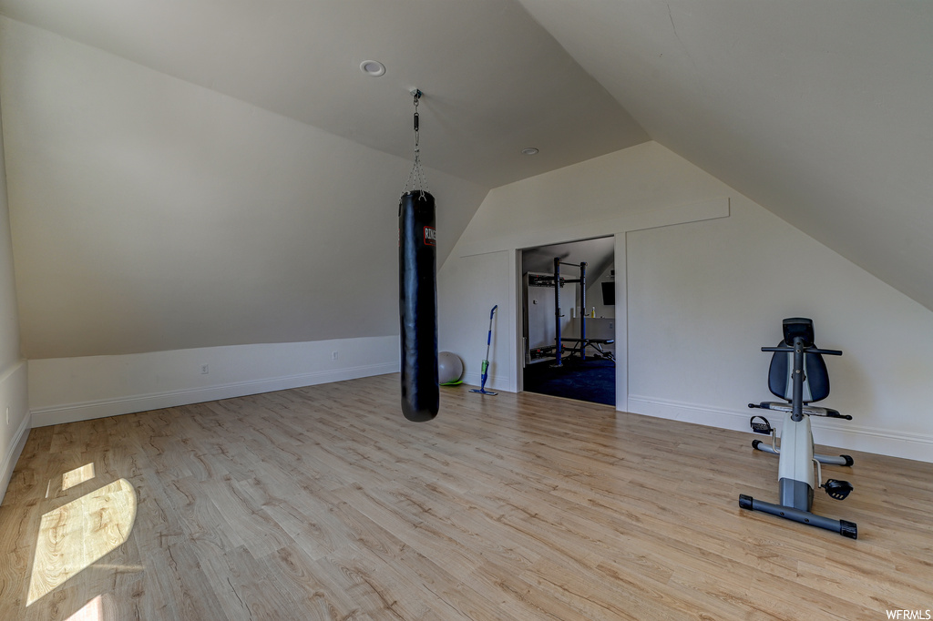 Workout area featuring light hardwood / wood-style flooring and lofted ceiling