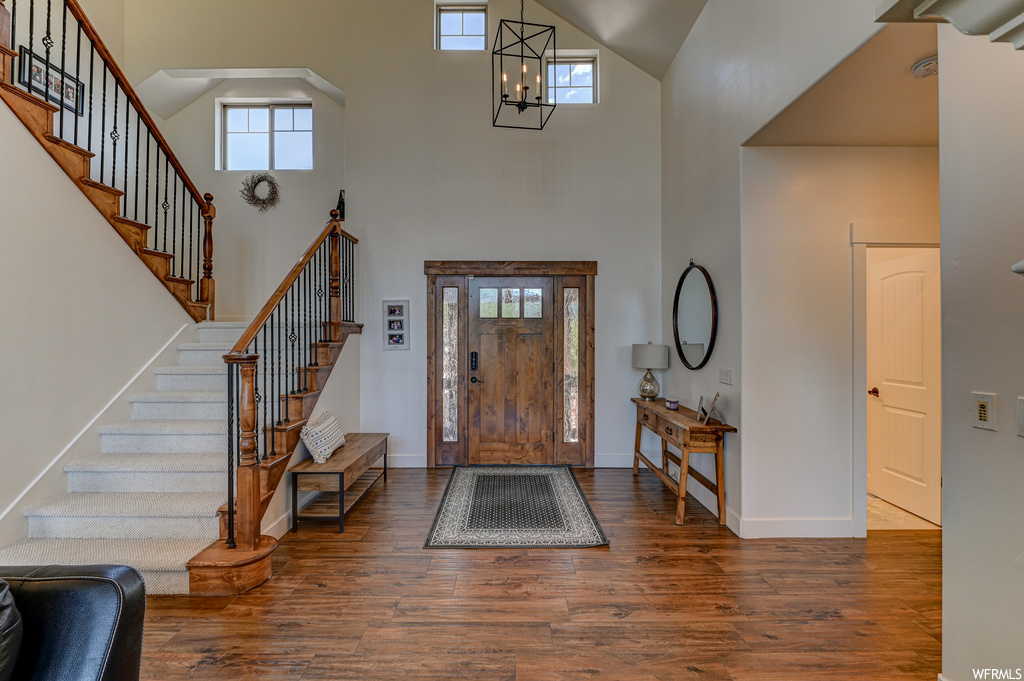 Foyer entrance with a chandelier, a high ceiling, and hardwood / wood-style flooring