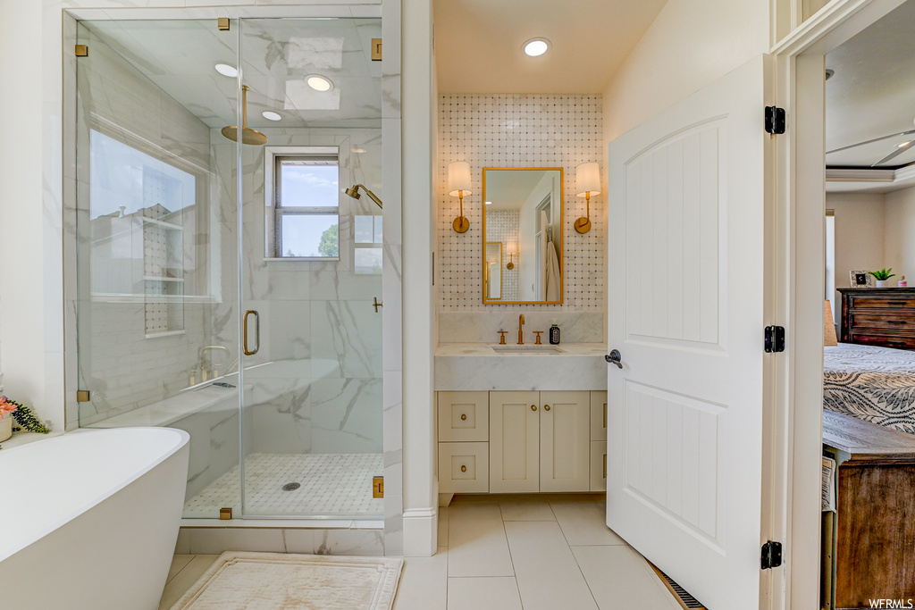 Bathroom featuring plus walk in shower, tile floors, and vanity