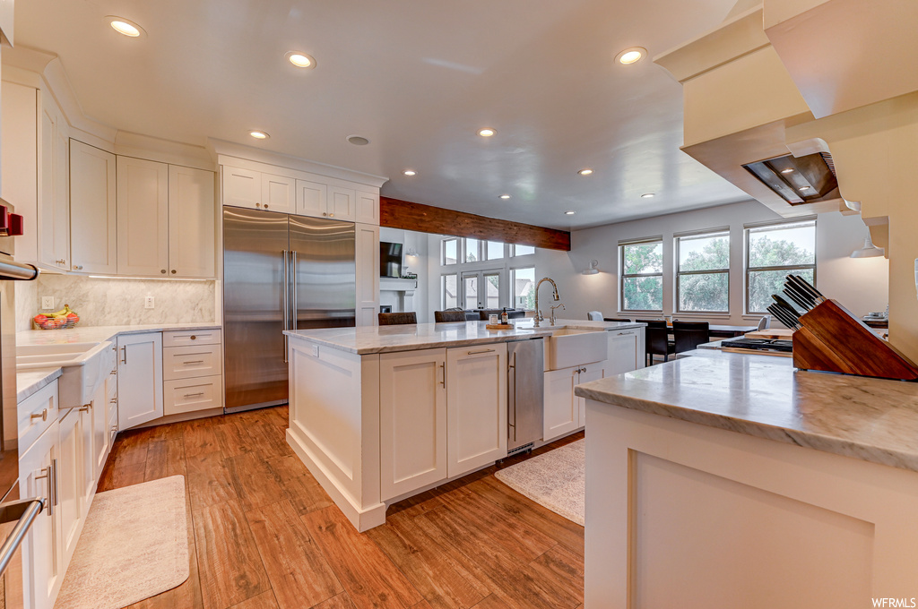 Kitchen featuring a center island, appliances with stainless steel finishes, light hardwood / wood-style flooring, and white cabinetry