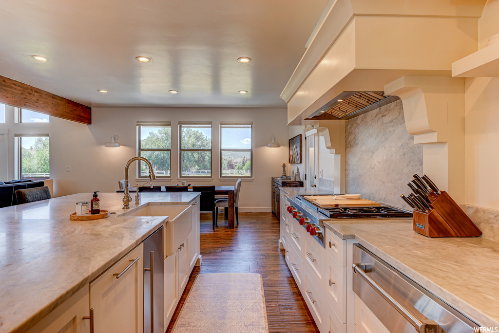 Kitchen featuring dark hardwood / wood-style floors, stainless steel gas stovetop, white cabinets, and sink