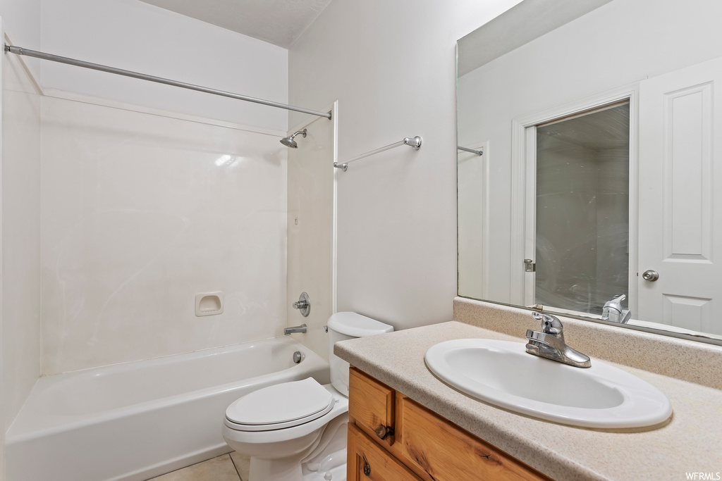 Full bathroom featuring vanity with extensive cabinet space, tile floors,  shower combination, and mirror
