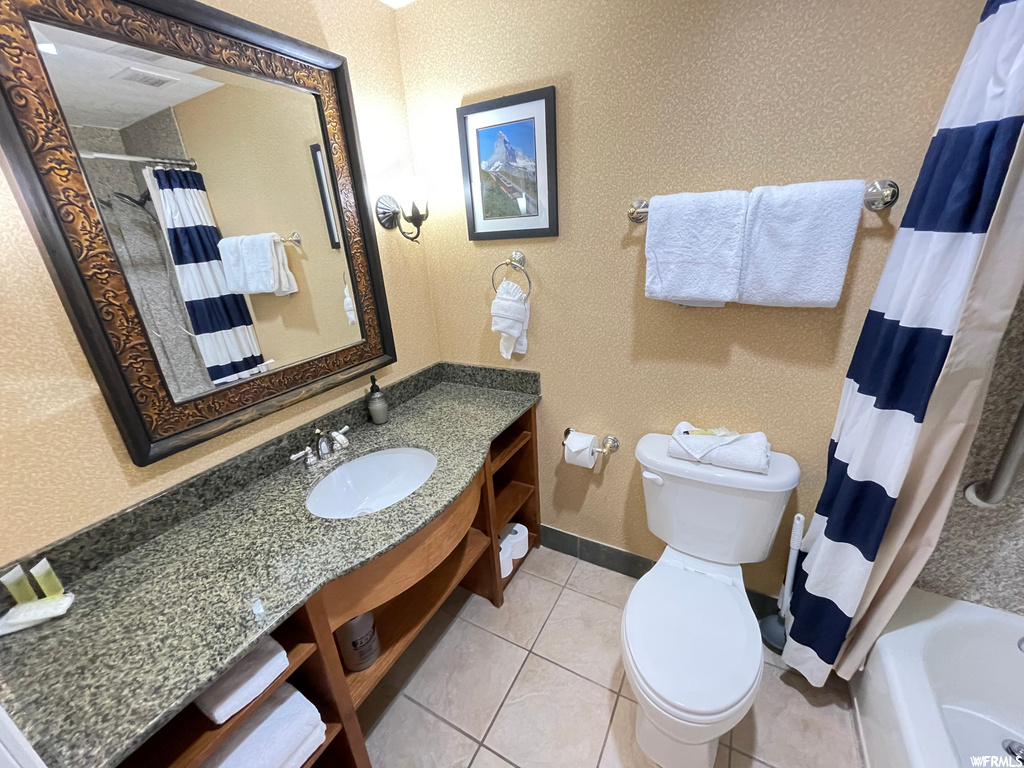 Full bathroom featuring shower / tub combo with curtain, oversized vanity, light tile flooring, and mirror