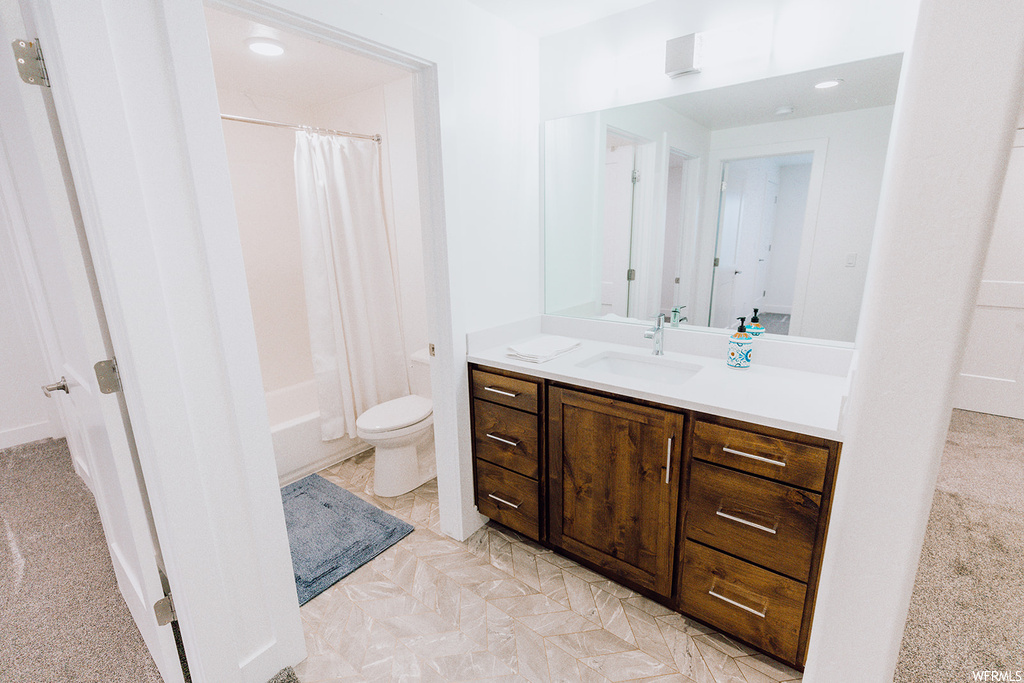 Full bathroom featuring shower / tub combo with curtain, vanity, light tile flooring, and mirror