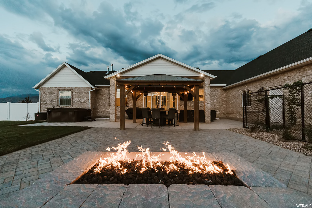 Rear view of house with a patio, a gazebo, and an outdoor firepit
