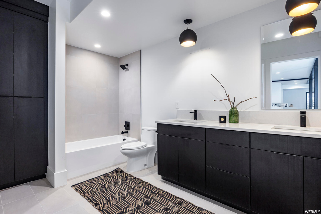 Full bathroom with light tile floors, dual bowl vanity, tiled shower / bath combo, and mirror