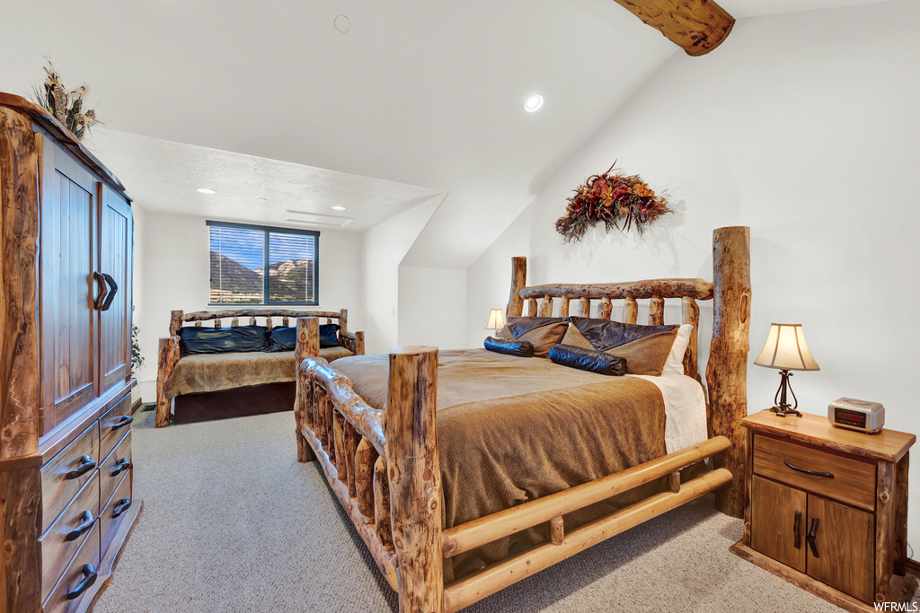 Carpeted bedroom featuring vaulted ceiling with beams