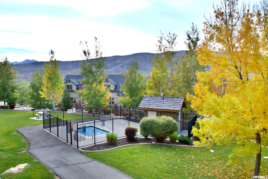 View of home\\\\\\\'s community featuring an outdoor structure, a lawn, and a mountain view