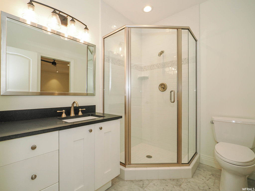 Bathroom featuring vanity, light tile flooring, mirror, and a shower with shower door