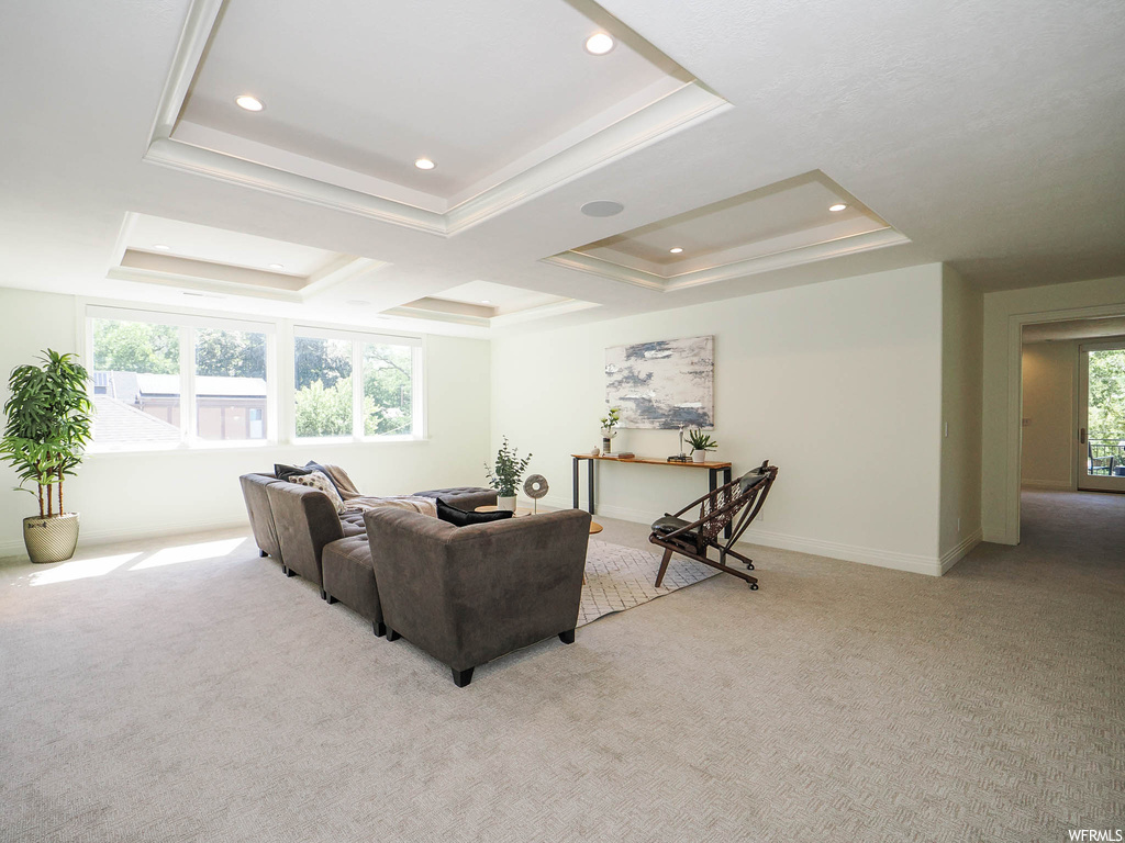 Living room featuring plenty of natural light, a tray ceiling, and light carpet