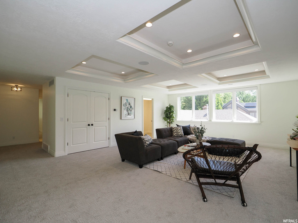 Living room featuring light carpet and a tray ceiling