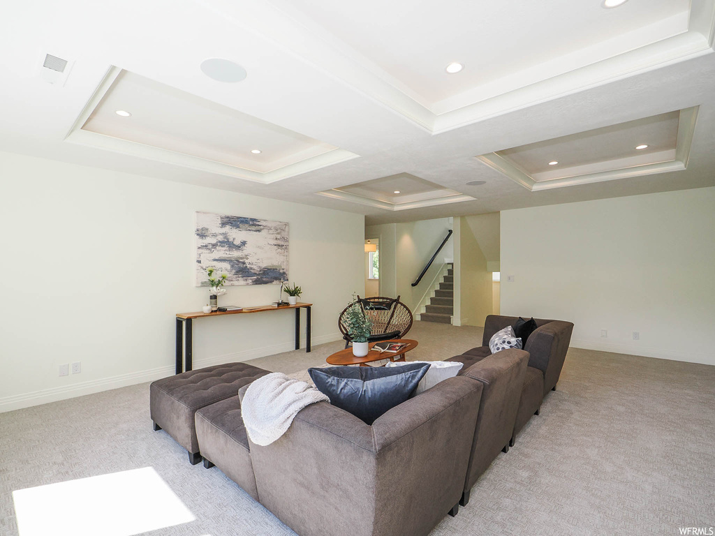 Living room with a raised ceiling and light carpet