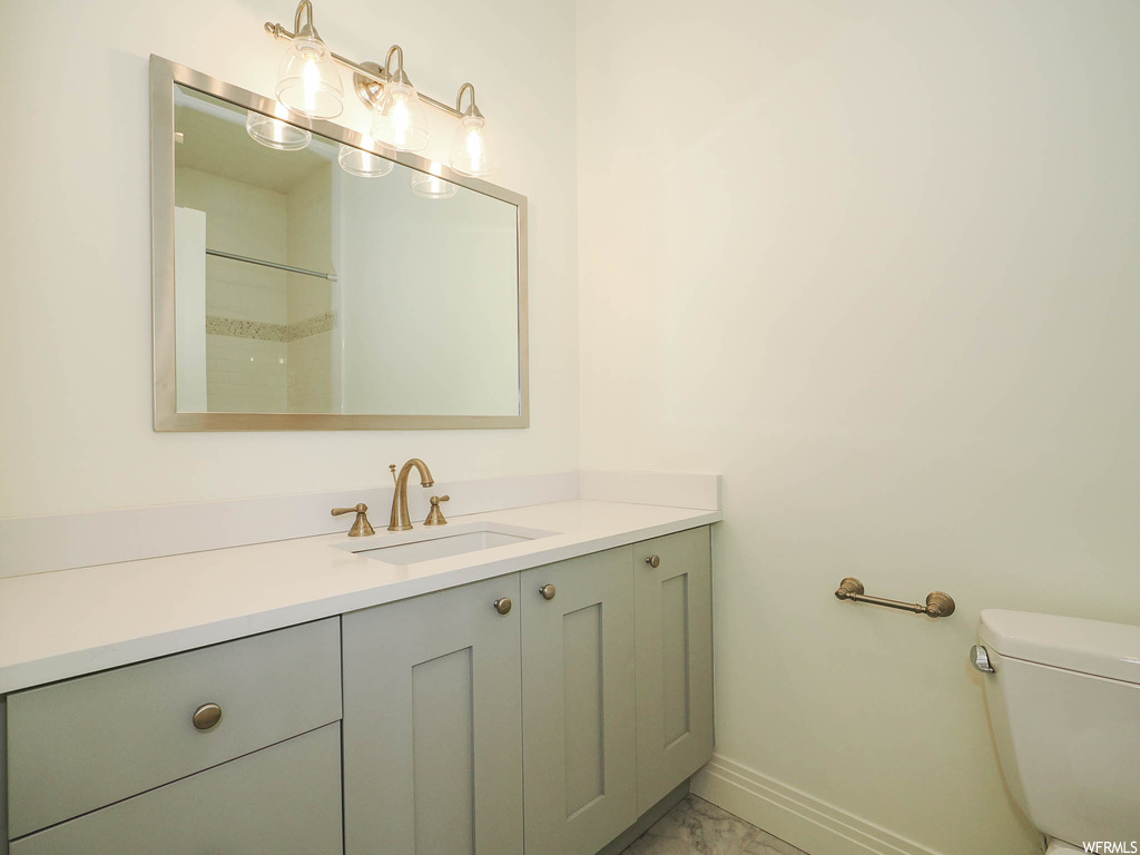 Bathroom featuring vanity, light tile flooring, and mirror